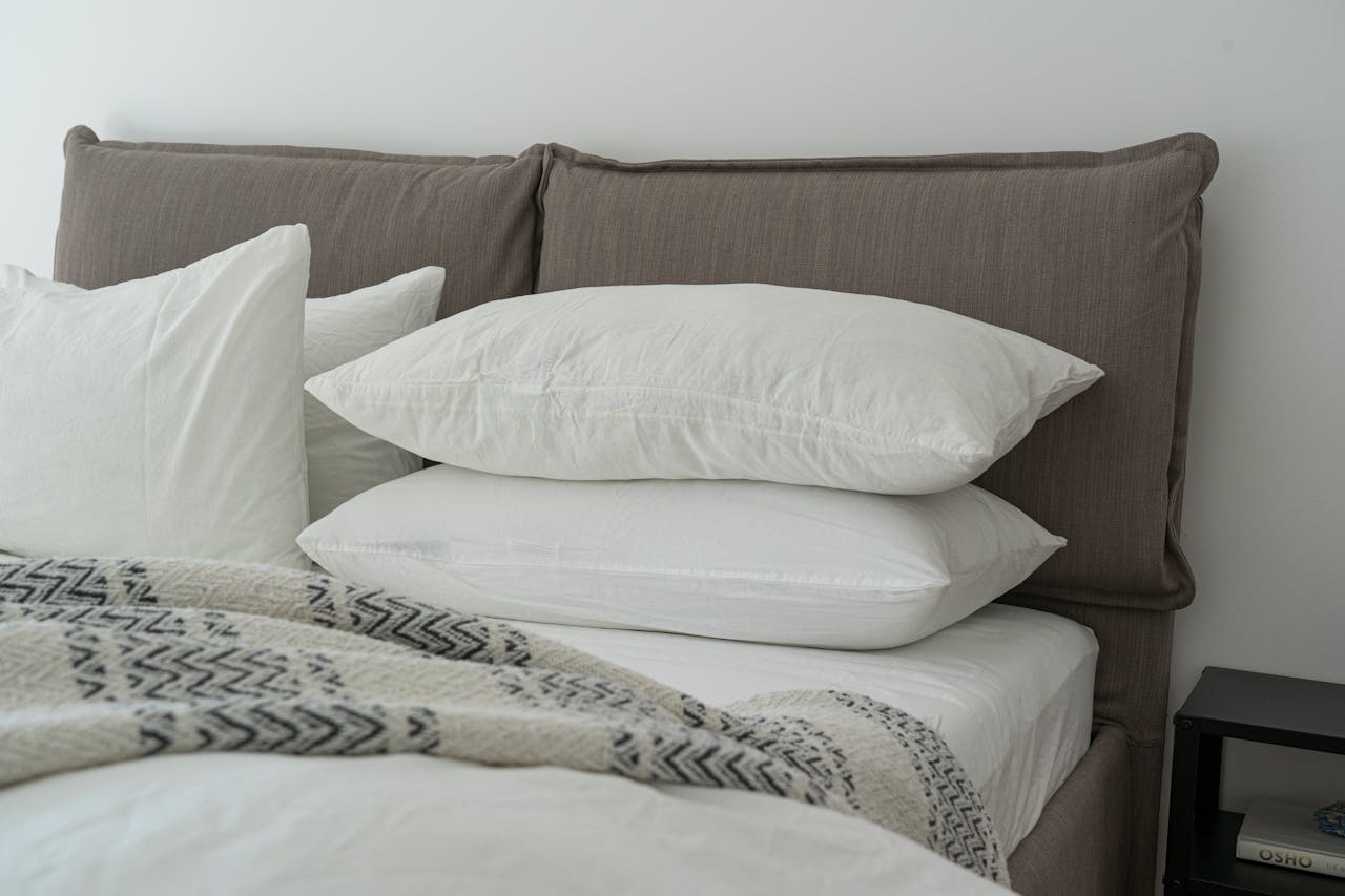Home Modern bedroom featuring clean white bedding and pillows for a cozy and inviting atmosphere.